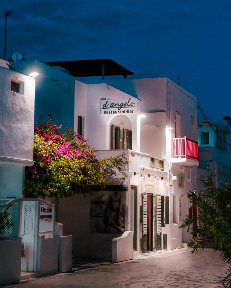 d'angelo Restaurant-Bar storefront at night with bougainvillea